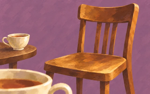 An unused chair stands beside a second teacup, while the edge of another cup appears in front.
